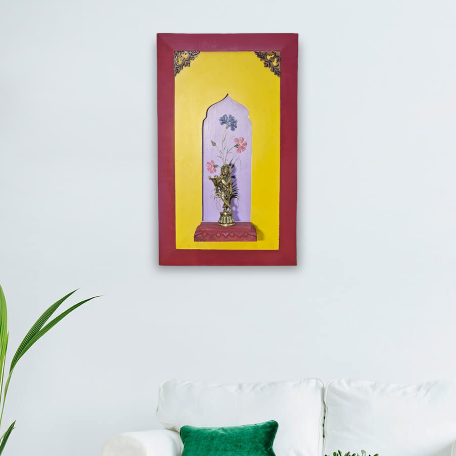 Brass lord Krishna on a wooden stand with a beautiful painting in the background