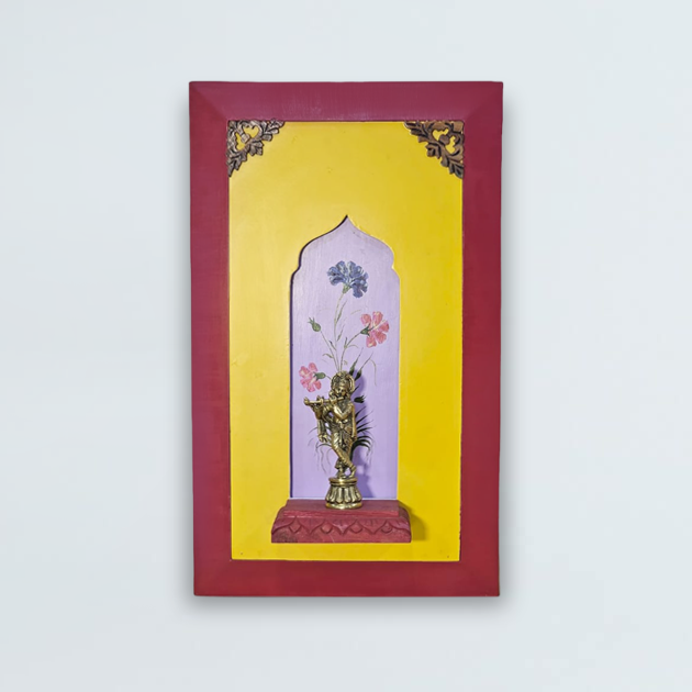 Brass lord Krishna on a wooden stand with a beautiful painting in the background