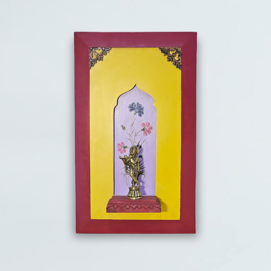 Brass lord Krishna on a wooden stand with a beautiful painting in the background